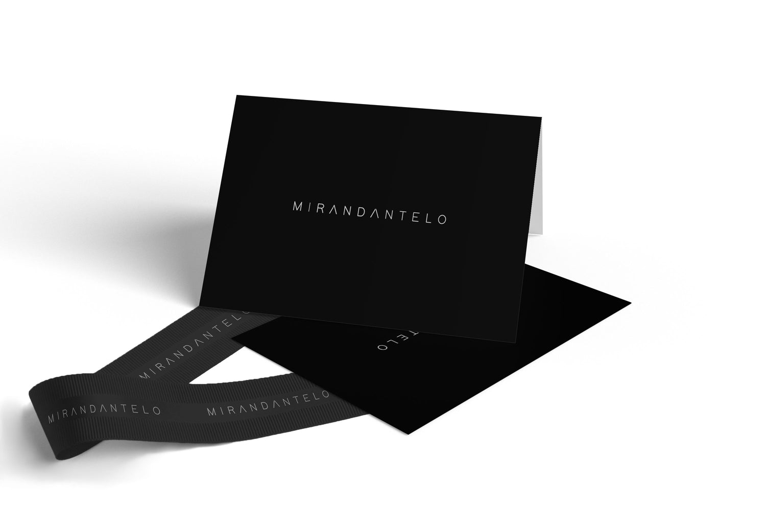 Tarjeta de regalo negra con logo Mirandantelo impreso en blanco.